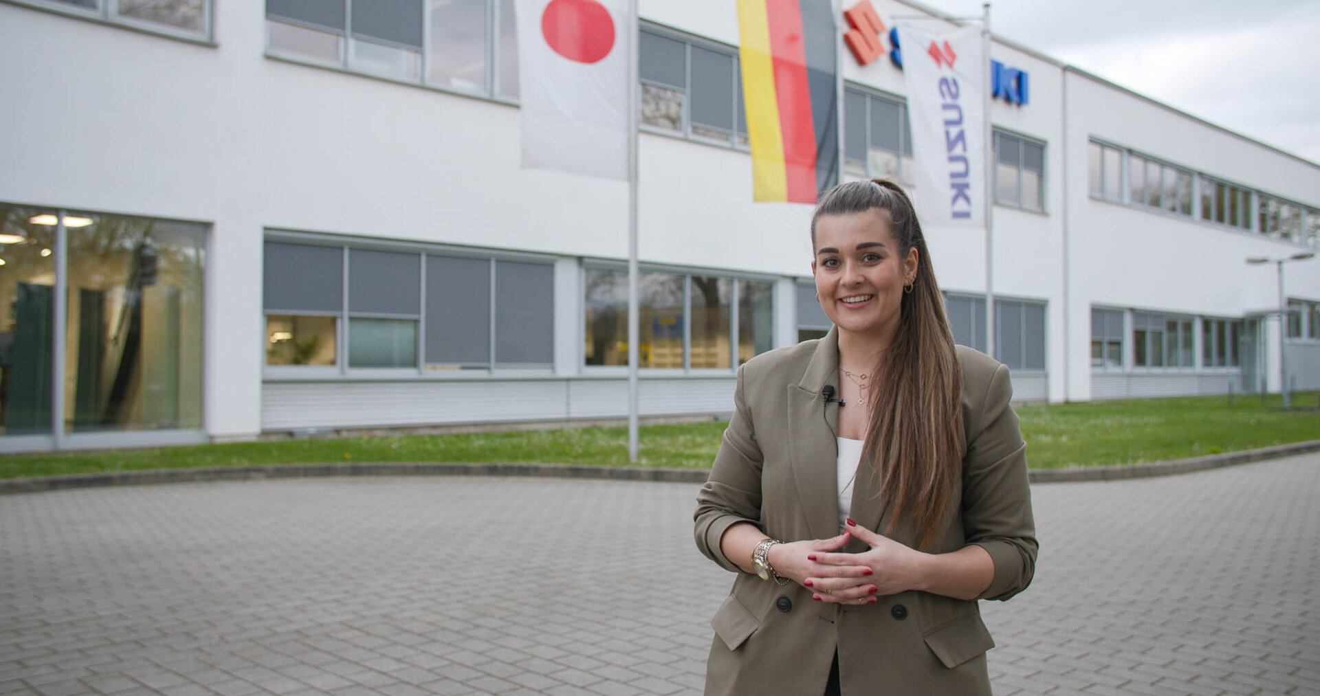 Mitarbeiterin vor dem Firmengebäude